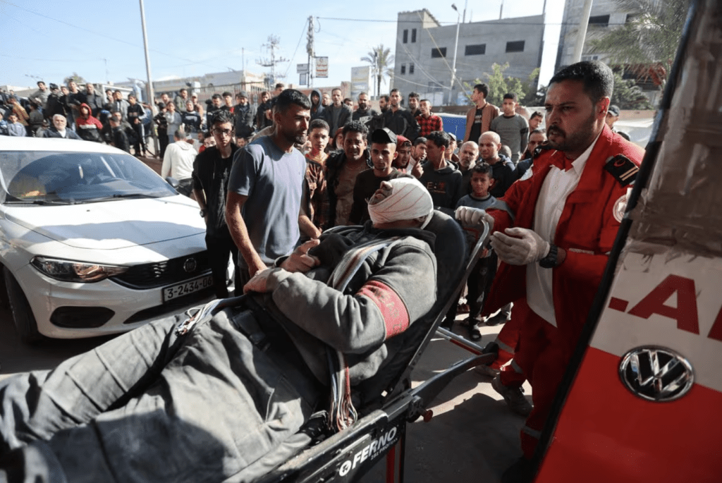 2023 年12 月4 日，在加沙走廊南部汗尤尼斯，一名在以軍空襲中受傷的巴勒斯坦人在以色列襲擊後被送往納賽爾醫院。路透社