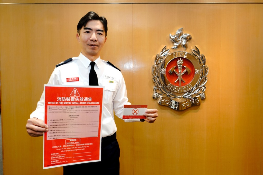 消防处消防区长（消防设施监督）冯家豪展示消防装置「损坏告示」样本。