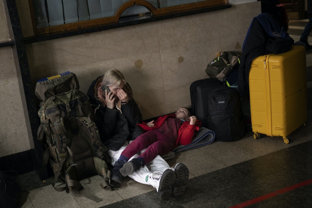 一對母女坐在車站地上，等待乘搭離開基輔的火車。AP