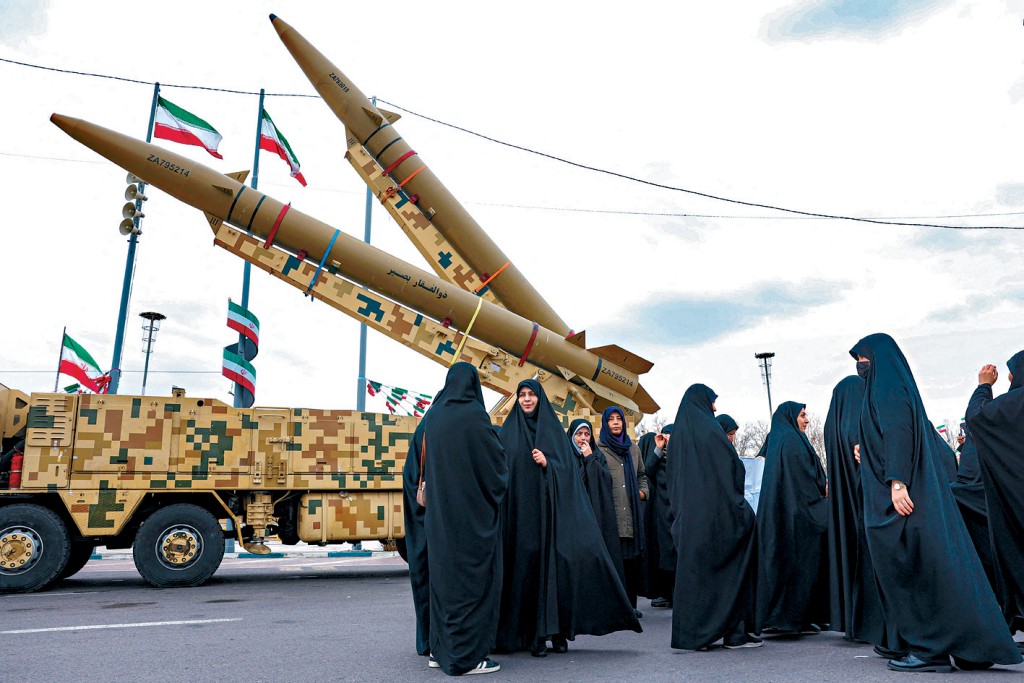在伊朗首都德黑兰上周举行一场纪念1979年伊斯兰革命47周年的集会，有妇女从弹道导弹发射车旁走过。