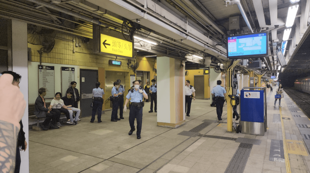 多名警员在月台上调查，月台长椅上的为死者4名家属。黎志伟摄