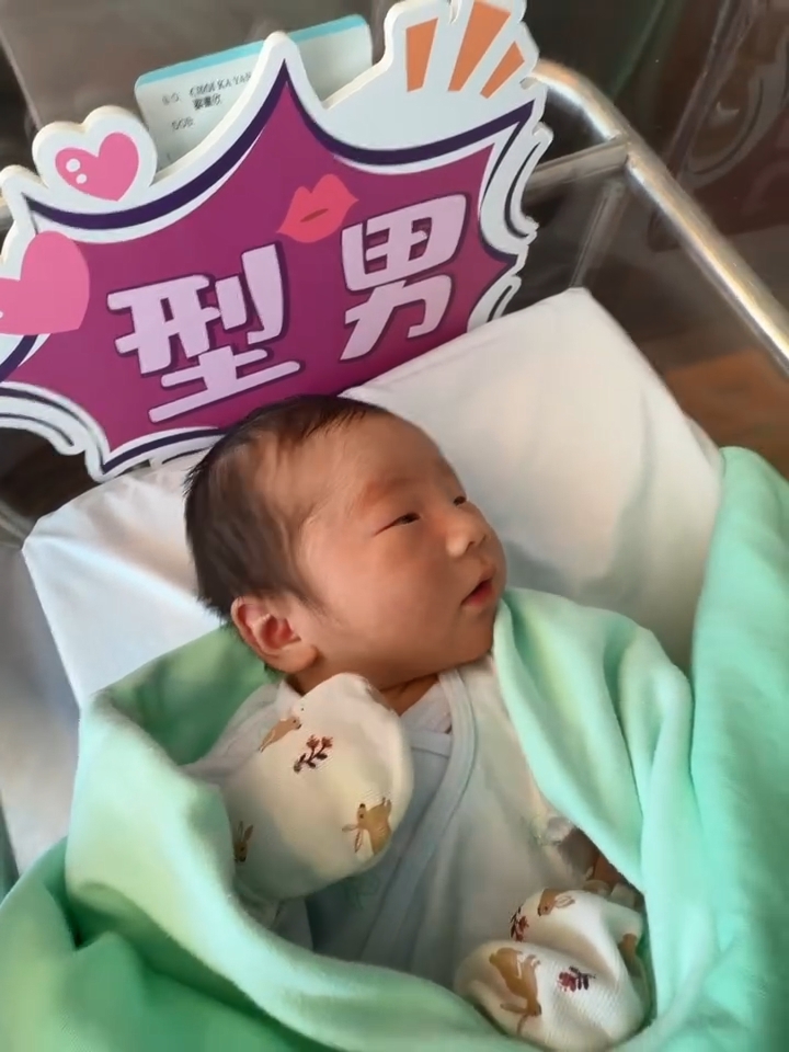 蔡嘉欣兒子被溫暖的白色毛巾與淺綠色包被包裹著。。
