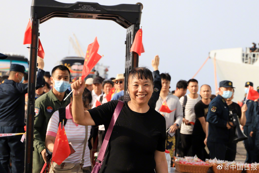 撤离的中国侨民手持中国国旗。