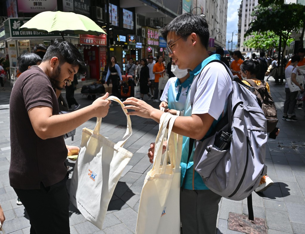 「香港海关青年发展计划」（「Customs YES」）青年成员（右一）向市民派发禁毒单张和宣传品。