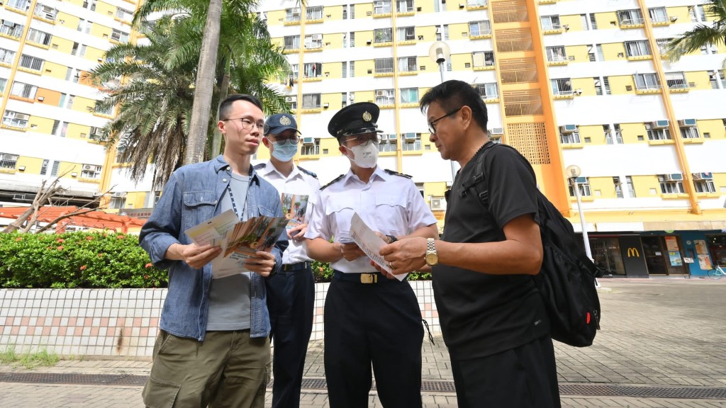 食環署人員向當區居民派發宣傳單張，呼籲市民提防蚊患。政府新聞處