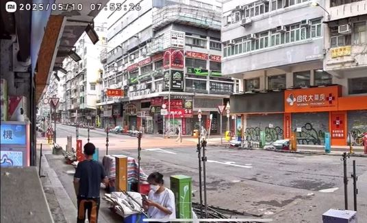 黑衣男淋油後離開，白衣男在外等候。店主提供影片