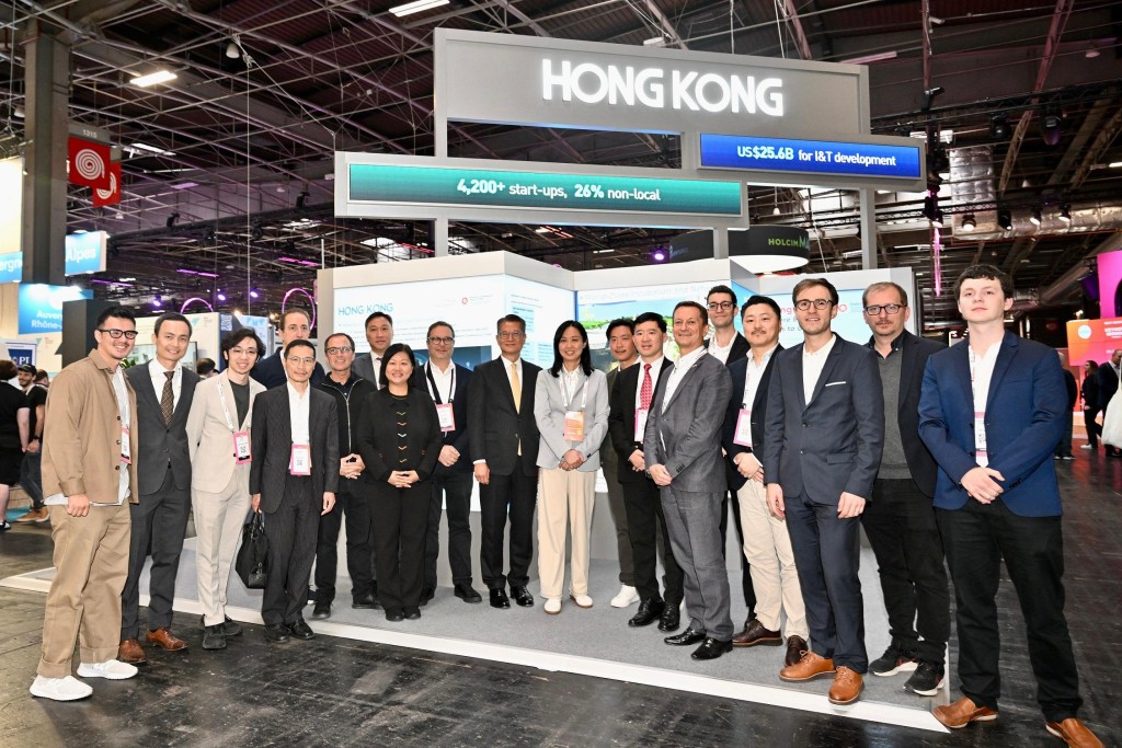 陳茂波（中）到訪展覽會的香港館，與參展的香港企業代表交流。