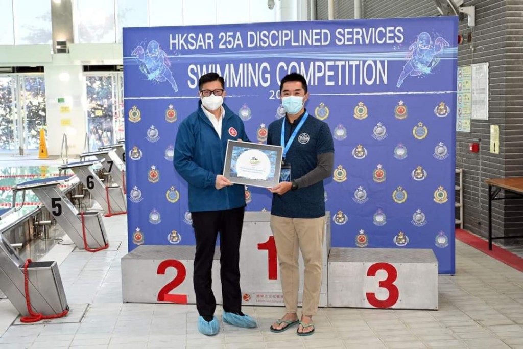 陳思達（右）曾任警察游泳會主席，出席活動時獲保安局局長鄧炳強（左）頒獎。
