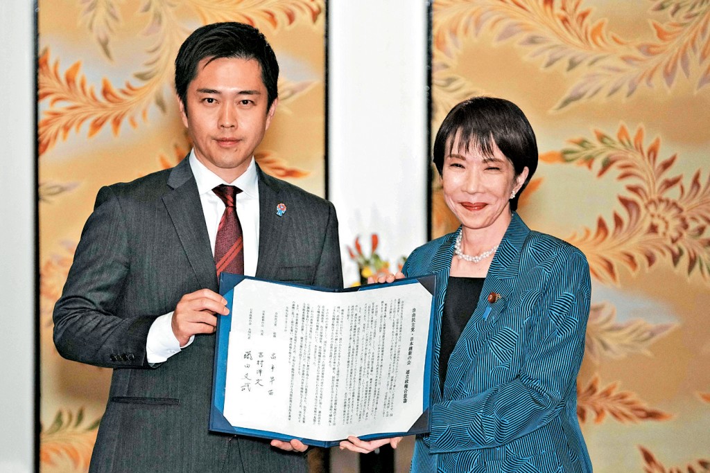 自民黨總裁高市早苗(右)與維新會聯合黨魁吉村洋文,周一簽署聯合執政協議書。