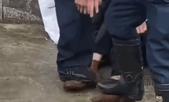 保安用脚踩住女子的足踝。