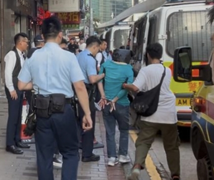 女疑犯被黑布蒙頭帶走。
