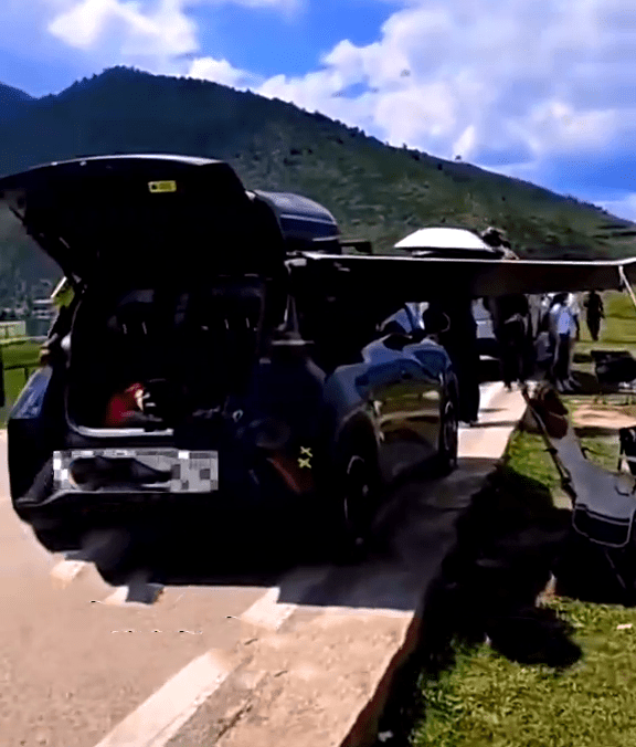 網傳影片可見，一架休旅車在一條路與草地之間搭起了一個帳篷。