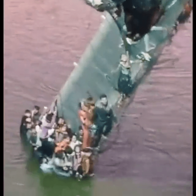 影片截圖可見有成人及兒童抓住還未墮海的橋身部分等待救援。