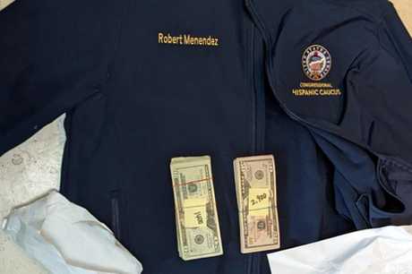 照片中可見有梅南德斯名字的夾克，以及調查人員在信封內查獲的現金。美聯社