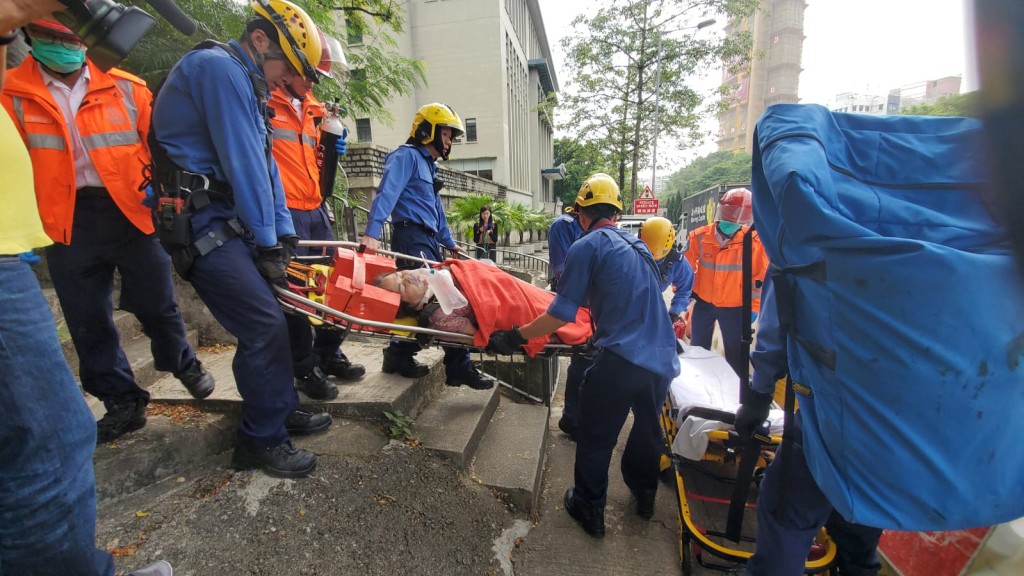 救護員將傷者抬下山送院。歐陽偉光攝