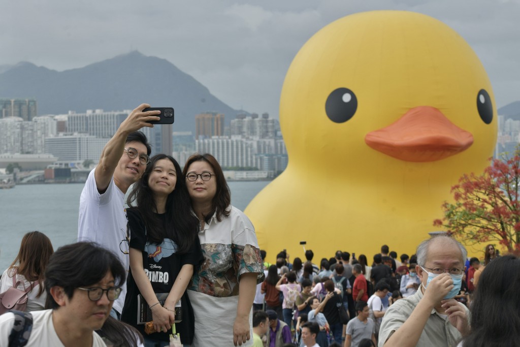 维港橡皮鸭展览6月18日完结，早上有市民冒雨前来打卡。（陈浩元摄）