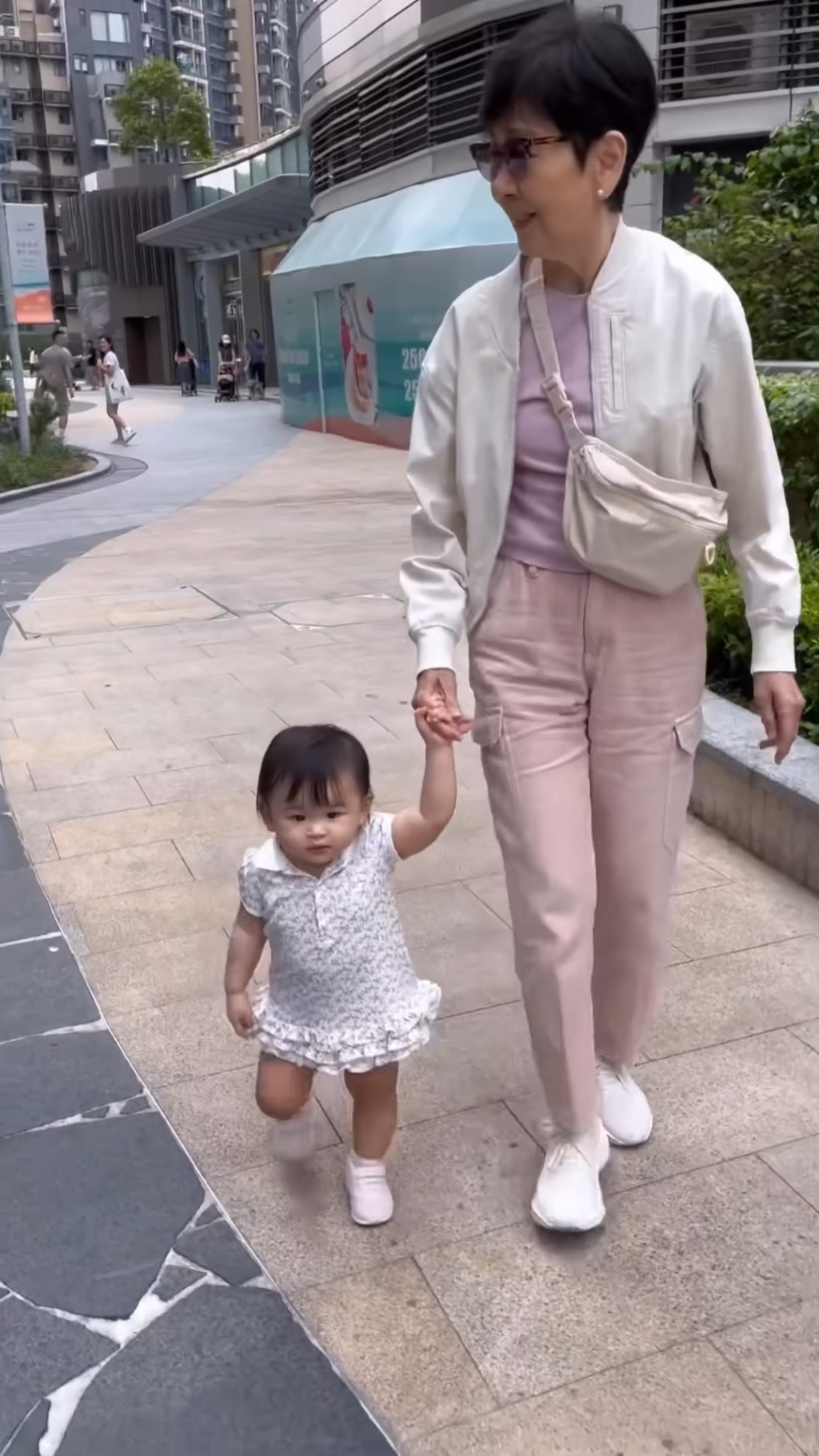 这时才见到石修的太太黄茹丽拖着孙女散步。