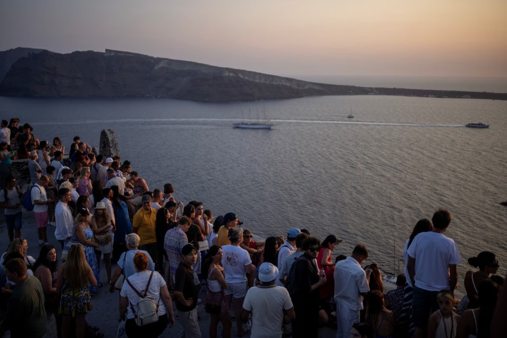 旅客在圣托里尼观赏爱琴海日落的风景。路透社