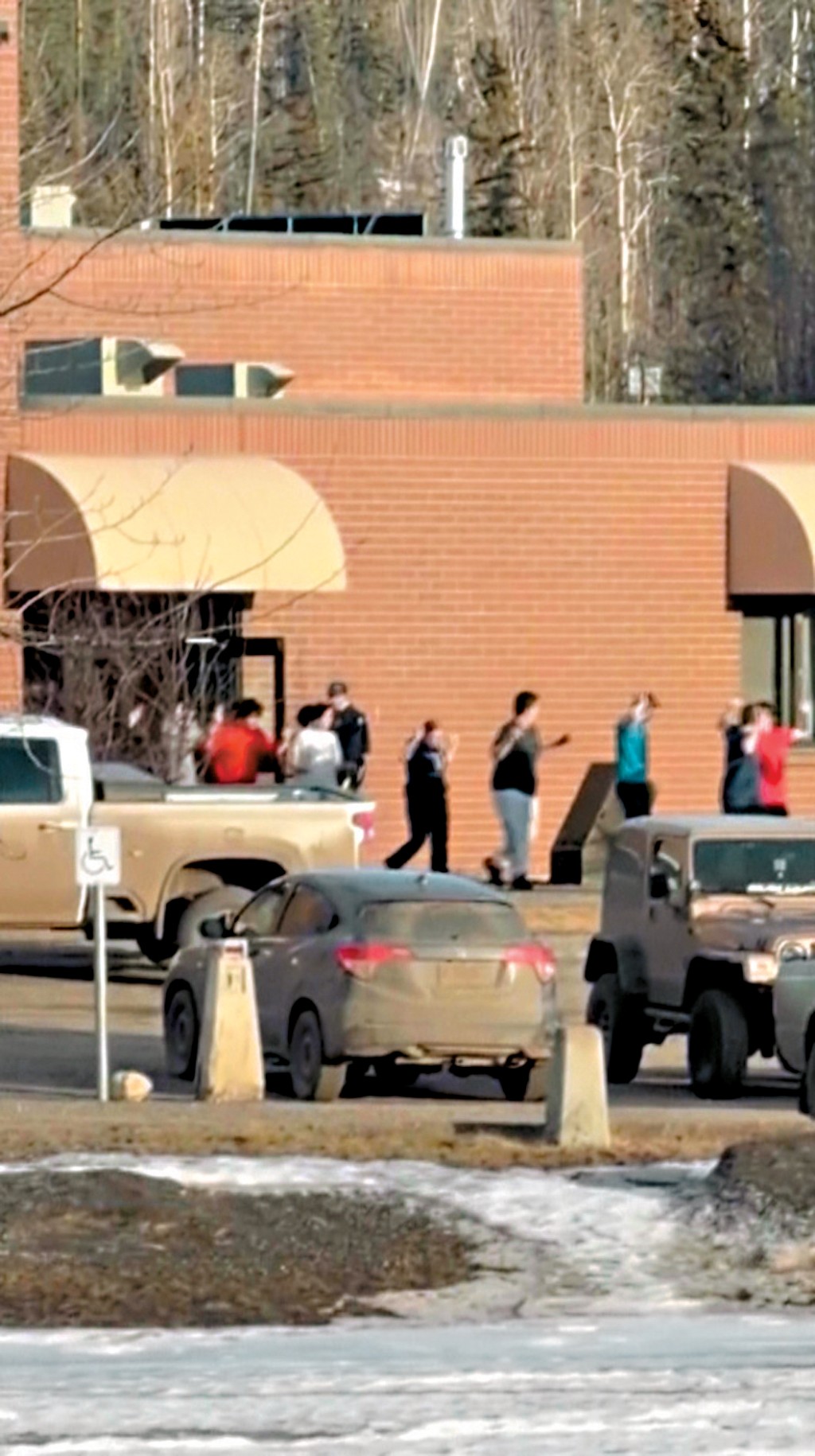 布勒嶺中學發生槍擊案後， 學生舉手撤離學校。