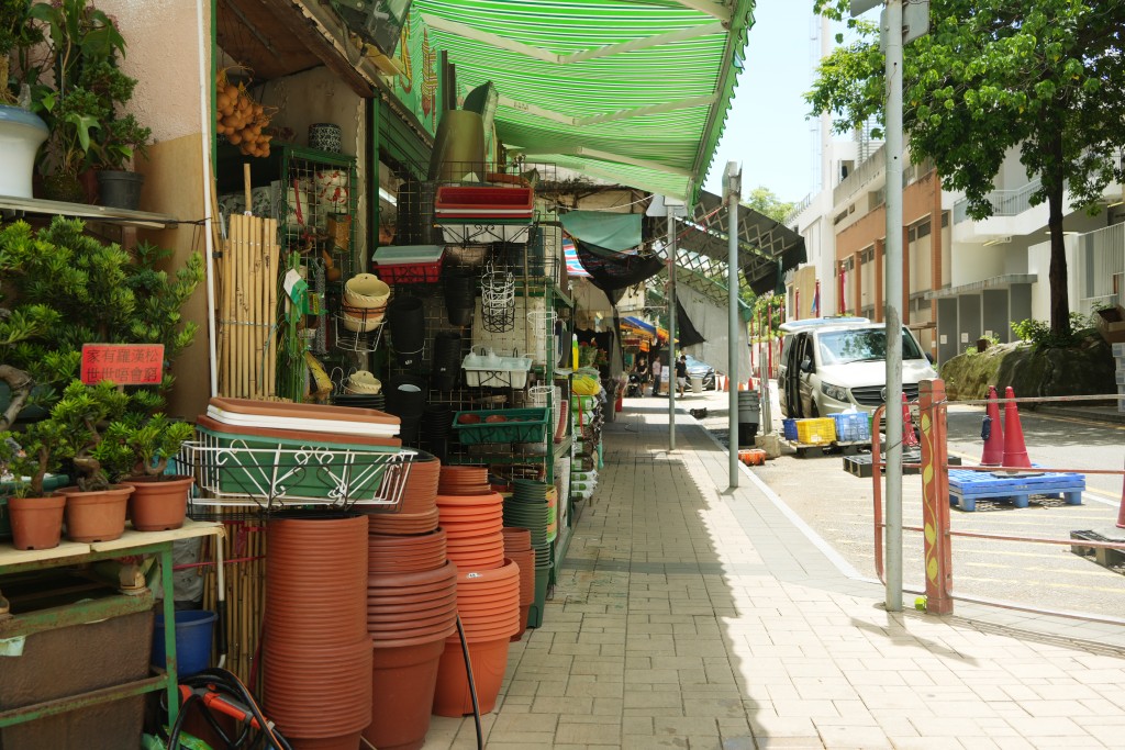 有花店將裝滿盆栽的雙層鐵架，放置行人路上。吳艷玲攝