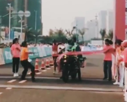 海口馬拉松鬧笑話,主辦單位攝影車搶先選手衝斷終點彩帶。(網圖)