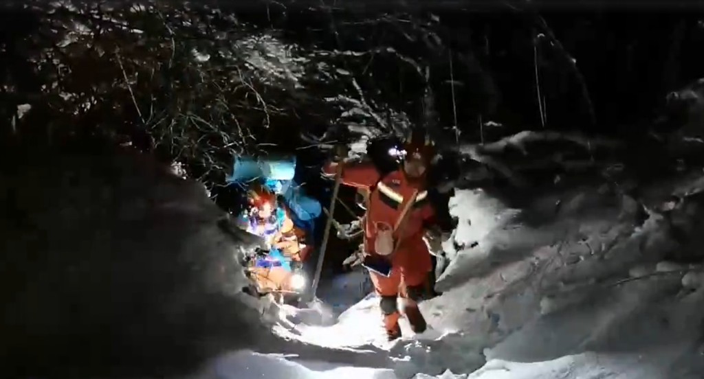 消防冒雪徒步上山救人。影片截圖