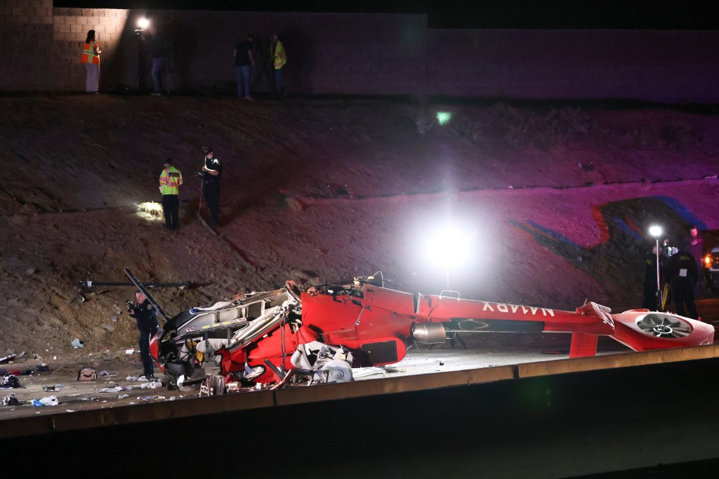 墜毀的直升機橫亙公路上。美聯社