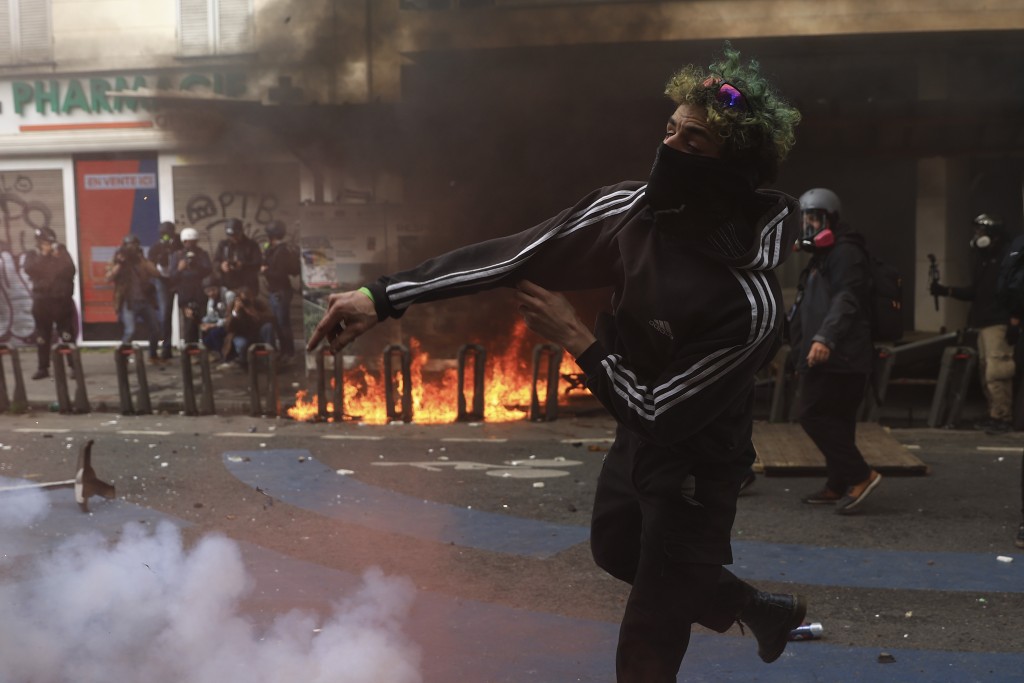 一名青年在巴黎举行的示威活动中投掷物体。AP