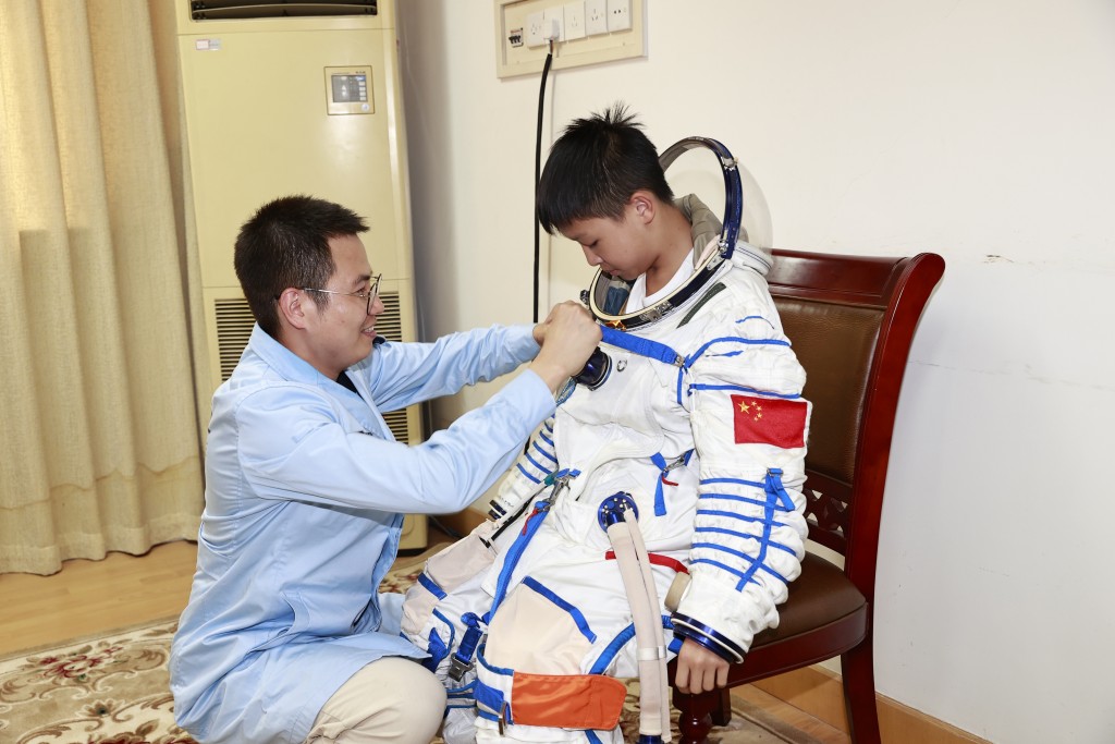 体验营学员在北京航天城体验穿脱航天服。政府新闻处图片