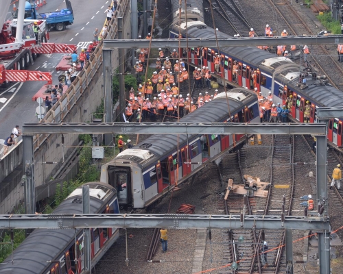 港鐵工程人員正將出軌的車廂吊起並扶正。
