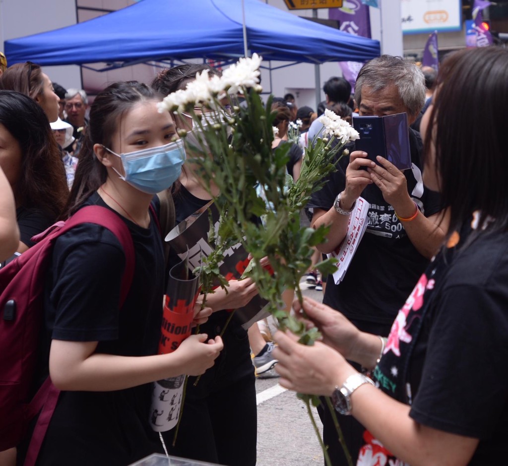 遊行市民帶同鮮花悼念墮斃的反修例市民。