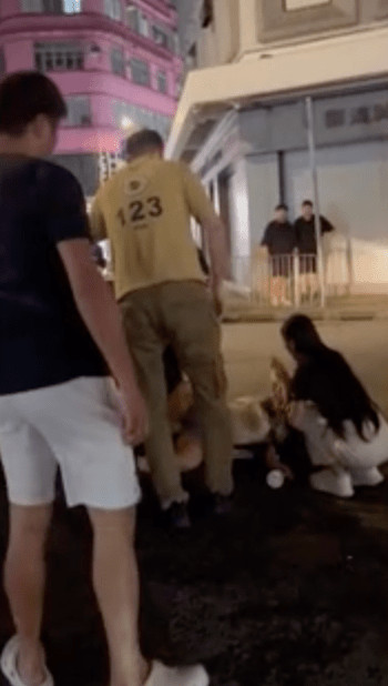 一名外籍男子及一名長髮女子見狀立即上前照料。 一名外籍男子及一名長髮女子見狀立即上前照料。