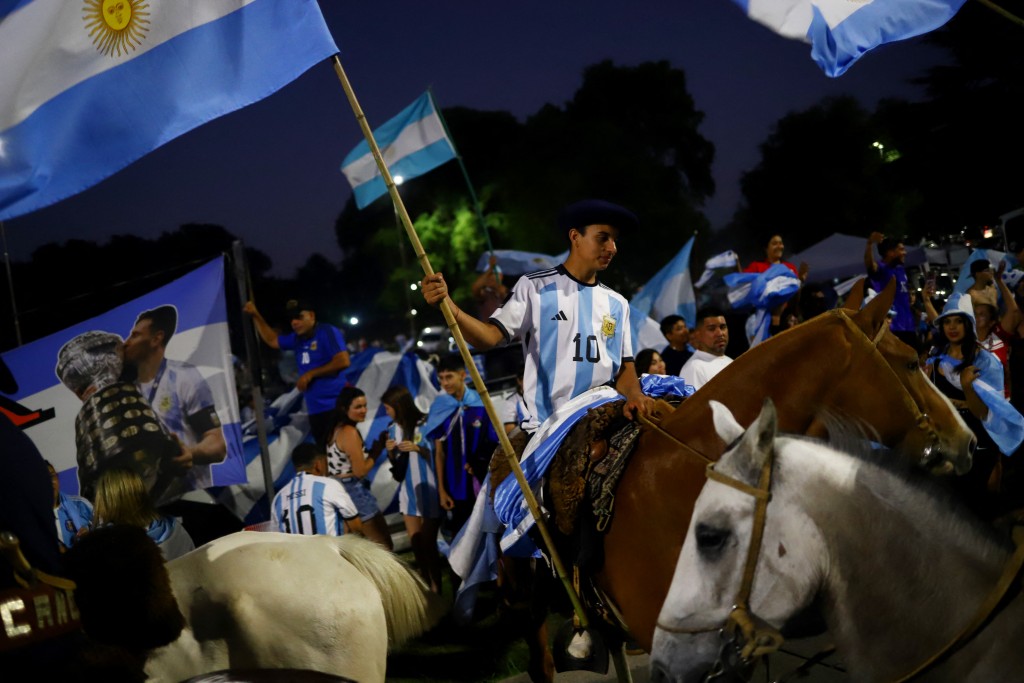 在阿根廷布宜诺斯艾利斯，球迷骑马聚集在阿根廷足球协会总部外庆祝。路透