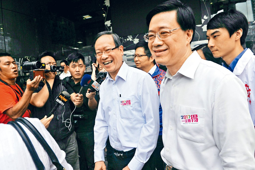 當年黎棟國擔任保安局局長（中），與副局長李家超落區宣傳政改派傳單。