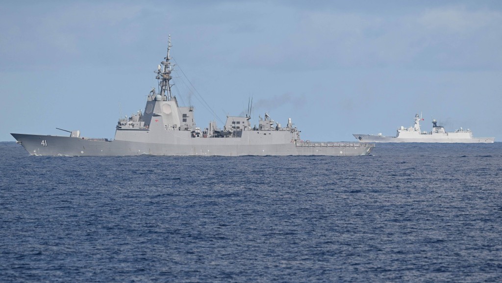 澳洲「布里斯班」號驅逐艦(左)進台海,解放軍海軍艦艇(背景右)全程跟蹤。 法新社