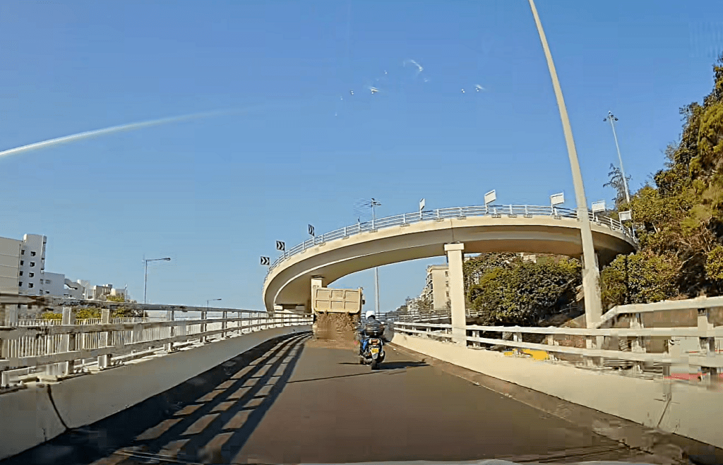 泥頭車車尾板突然鬆開，大量泥石傾倒而下。fb：車cam L（香港群組）