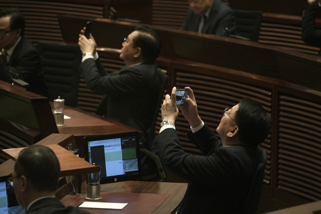政務司司長陳國基舉起手機拍下歷史一刻。