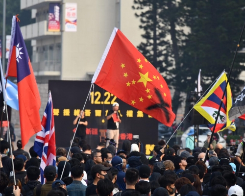 集會人士舉起美國旗、英國旗及象徵疆獨的旗幟。