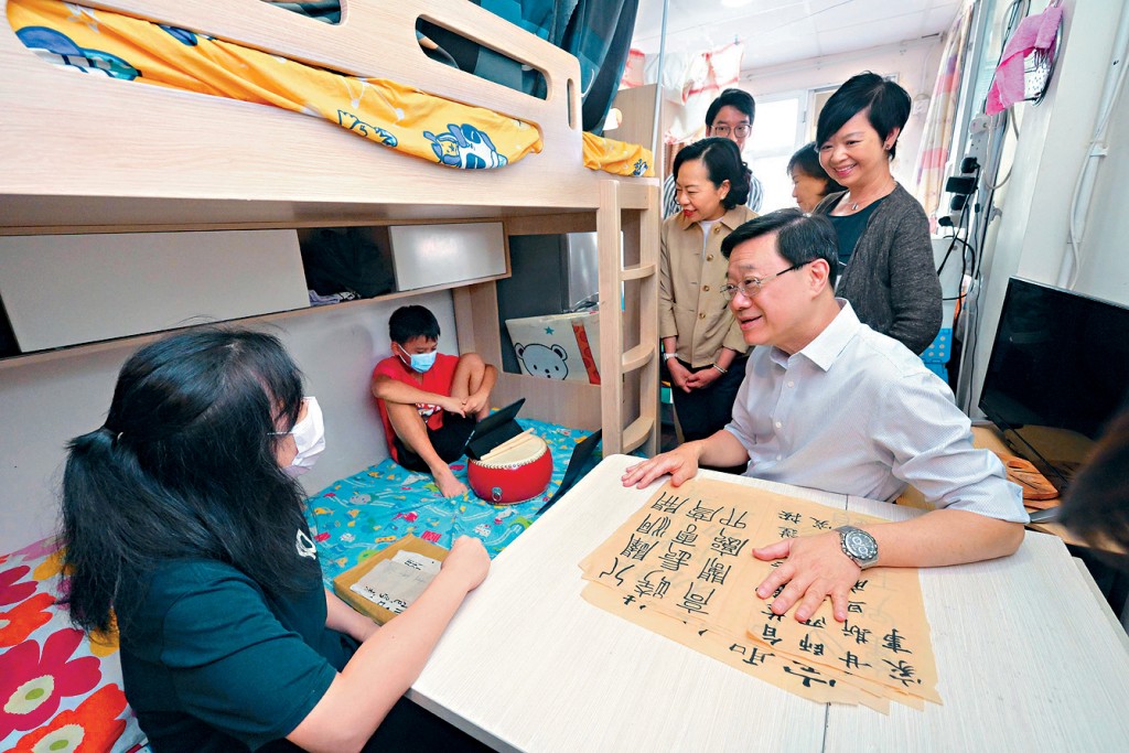 行政長官李家超去年在房屋局局長何永賢陪同下,探訪一家四口劏房戶。