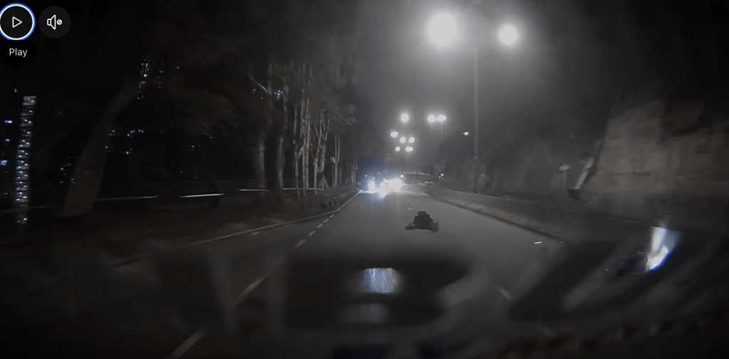 鐵騎士在路面翻滾半周後，全身向下滑行「磨薑」一段距離，橫臥行車線中央。