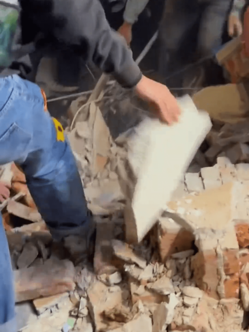 市民合力移開磚瓦將傷者救出。 市民合力移開磚瓦將傷者救出。