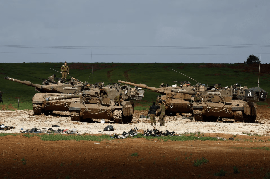 2024 年 1 月 30 日，在以色列加萨北部边境附近，以色列和哈马斯之间持续发生冲突，以色列士兵在坦克旁戒备。路透社