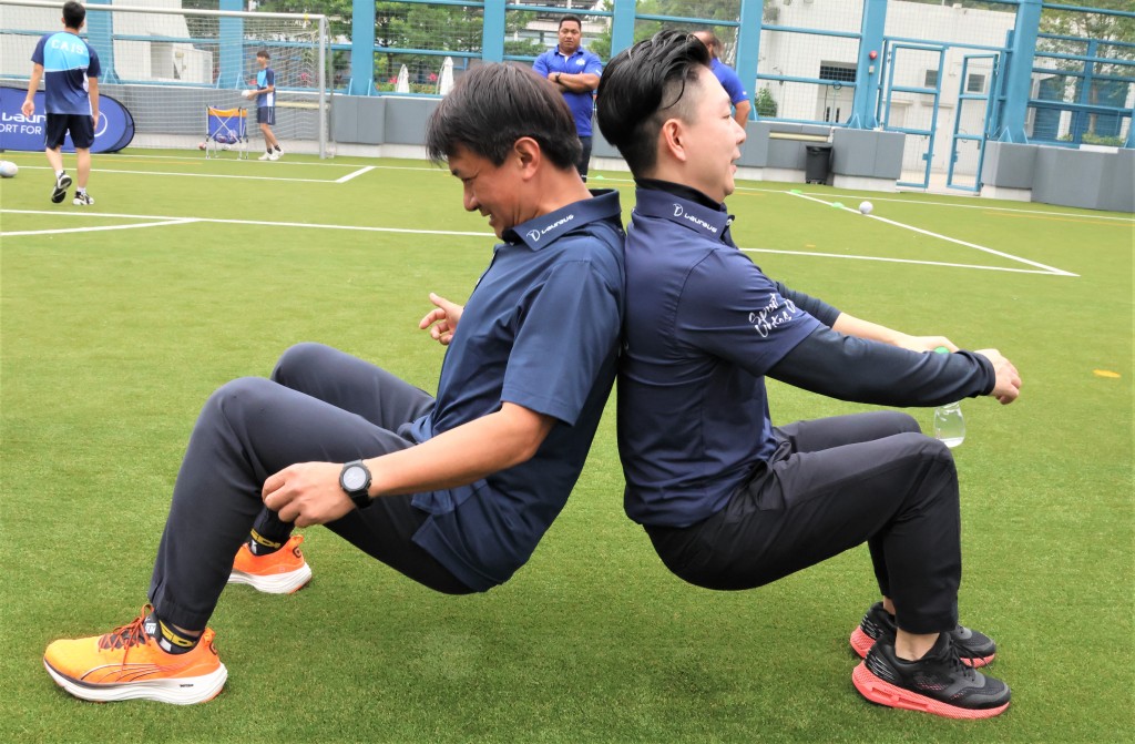 黃金寶（左）與李小鵬不愧慱奇運動員，坐下背對背互倚站起來全沒難度。 本報記者攝