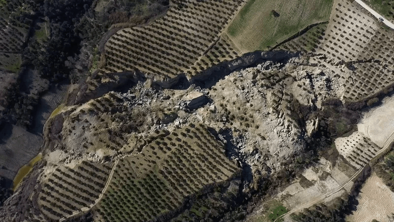 无人机空拍画面可以见到土耳其东南部一处青翠的橄榄园地震后被一分为二。路透