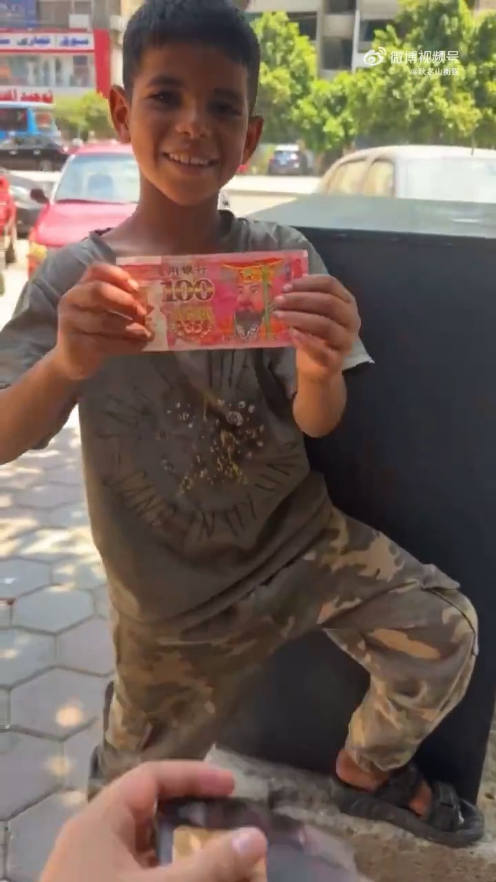 另一名網紅將一張陰司紙交予小孩。