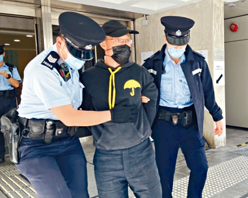 穿黃雨傘圖樣黑色衞衣男子,由警員帶走。