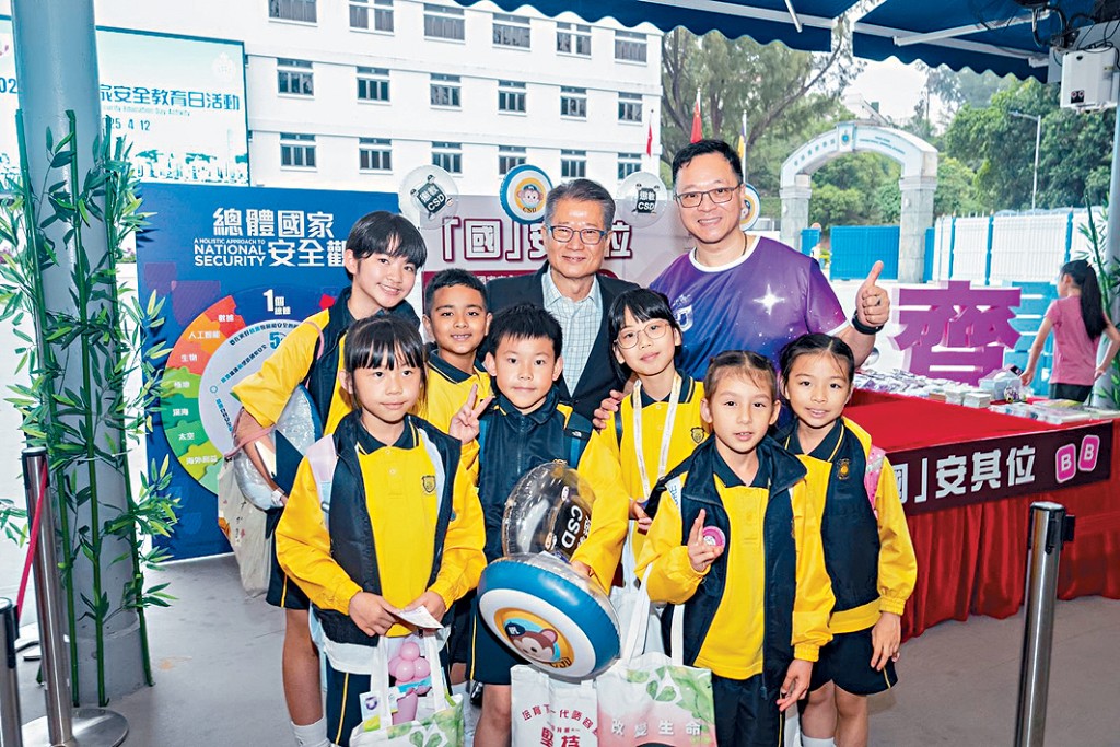 財政司司長陳茂波（後排右二）和懲教署署長黃國興（後排右一）與學生合照。