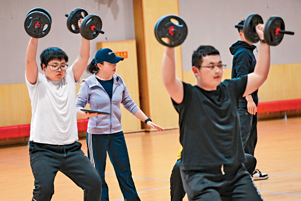 中國農業大學校園內，減脂老師指導學生進行力量訓練。