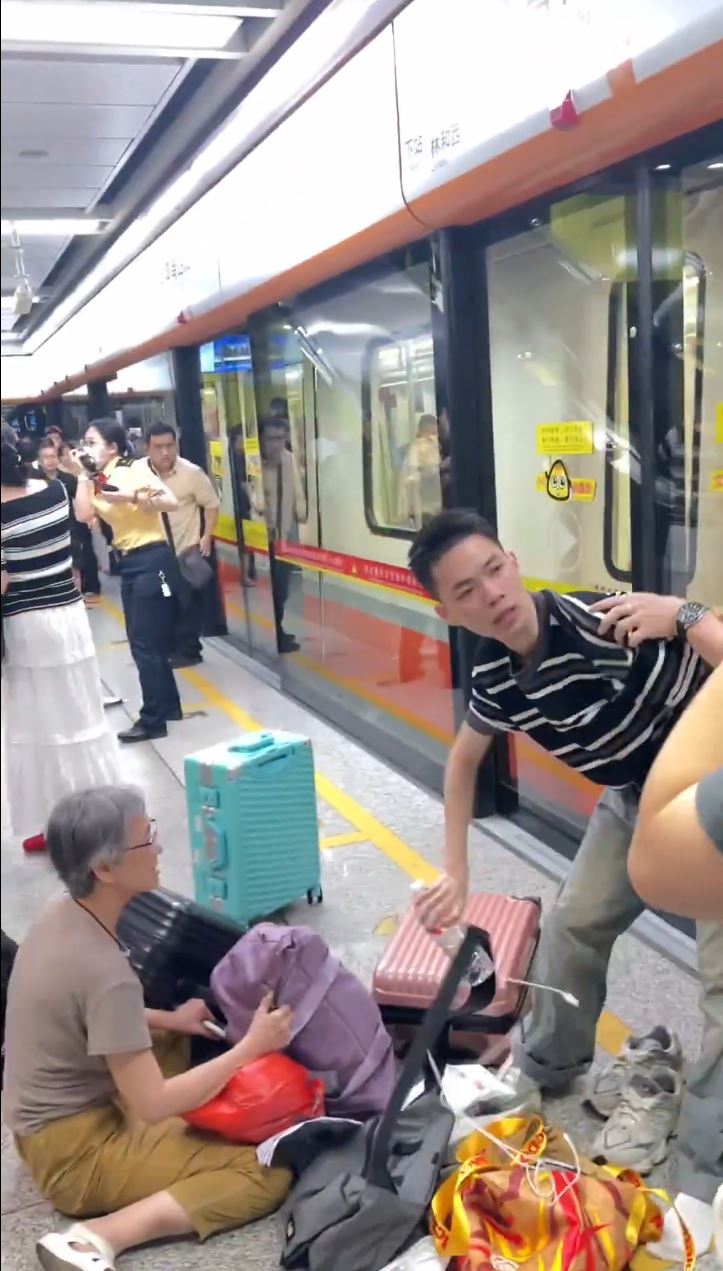 被喷中辣椒水乘客逃出车厢后，在月台用瓶装水洗眼。