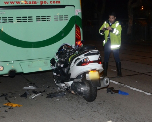 電單車車頭插入旅遊巴車底。